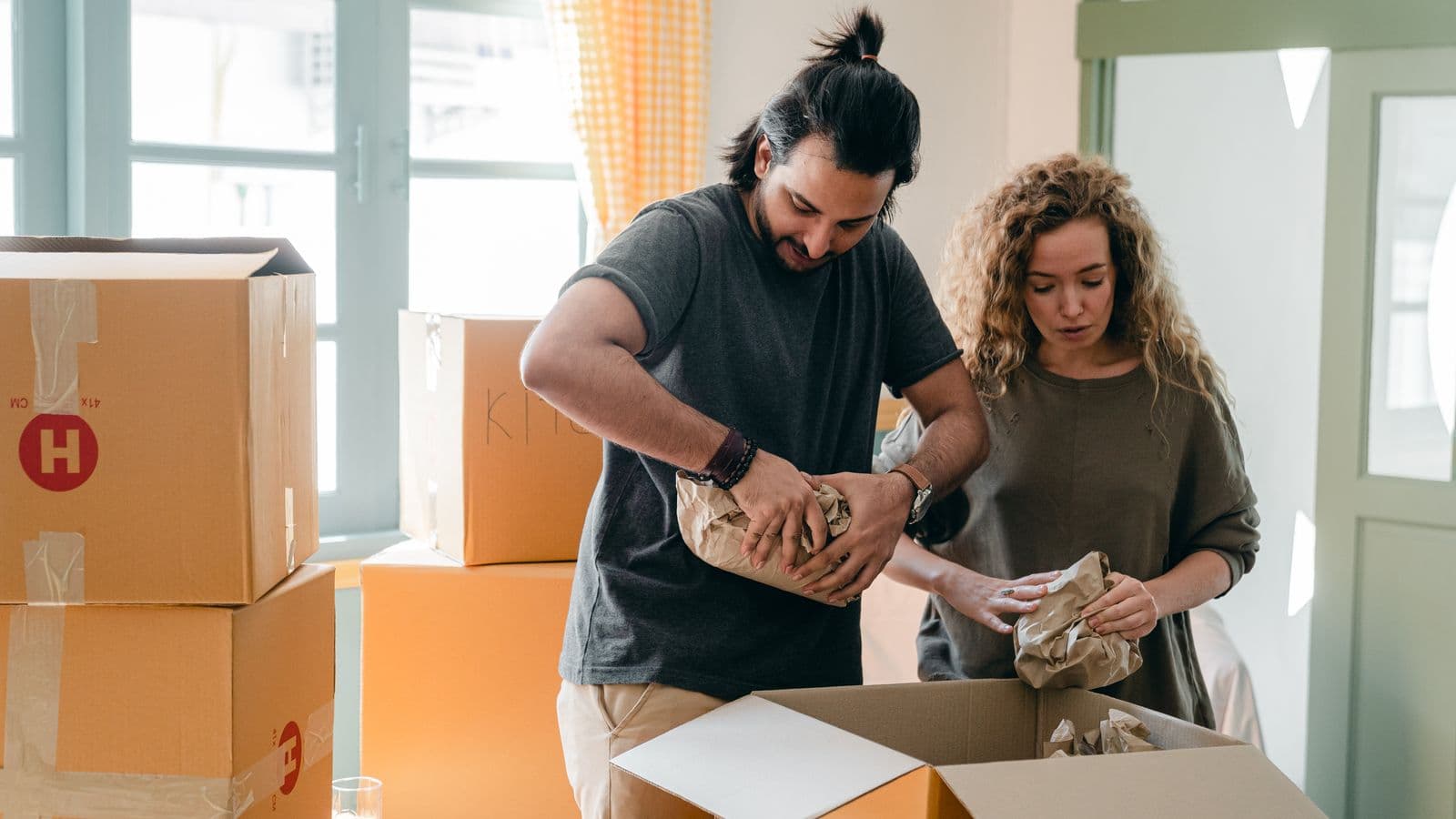 People carefully wrapping household items for a house move